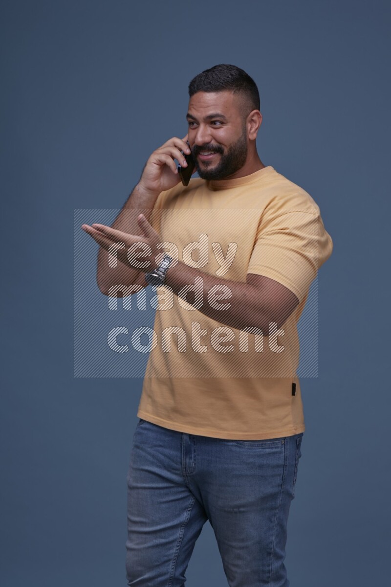 A man Calling on Blue Background wearing Orange T-shirt