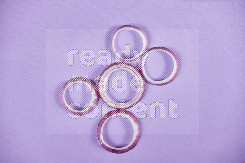 Red onions rings on purple background