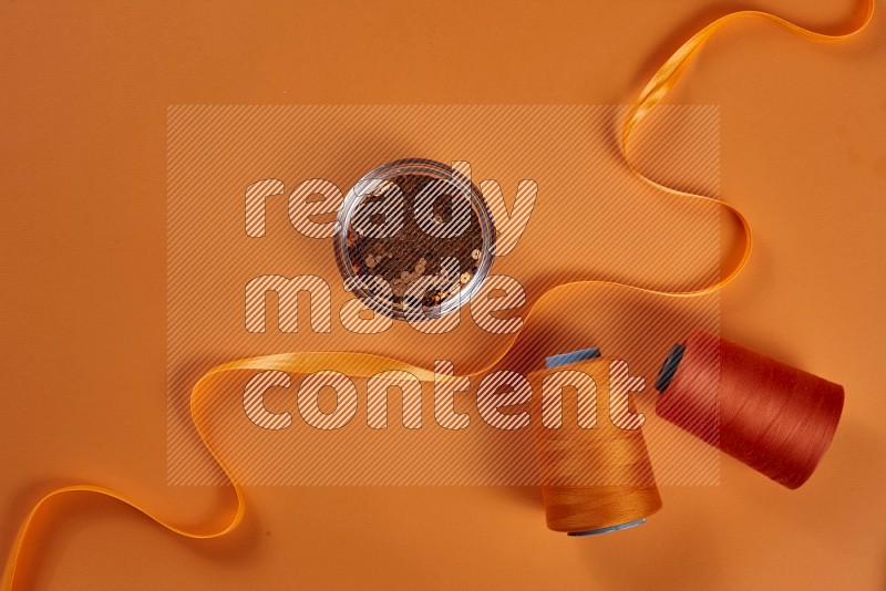 Orange sewing supplies on orange background