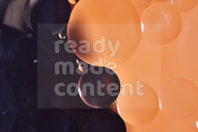 Close-ups of abstract oil bubbles on water surface in shades of black and orange