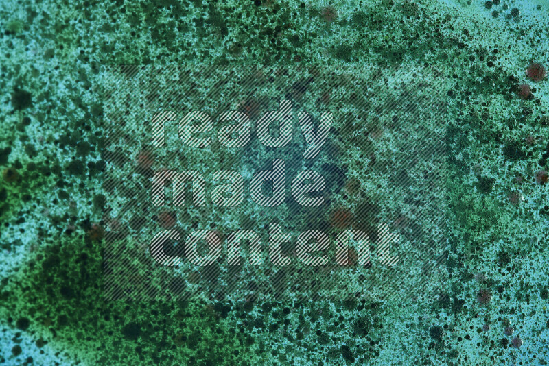 لقطات مقربة لقطرات ألوان مائية خضراء على سطح الزيت على خلفية خضراء