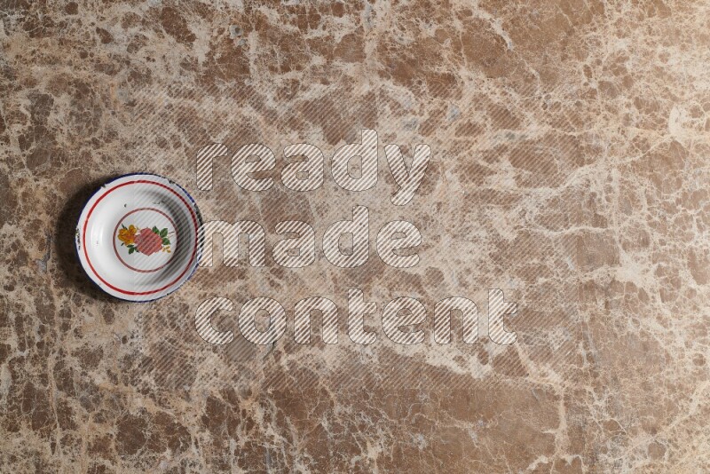 A vintage metal plate on beige marble background