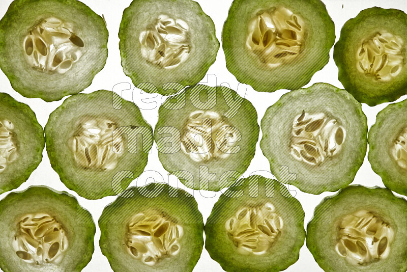 Cucumber slices on illuminated white background