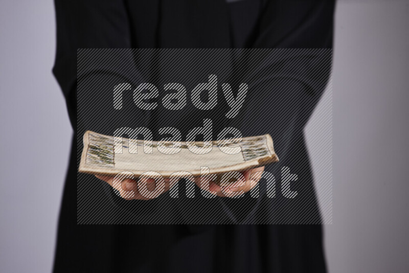 A woman in black abaya holding different pottery essentials in different positions