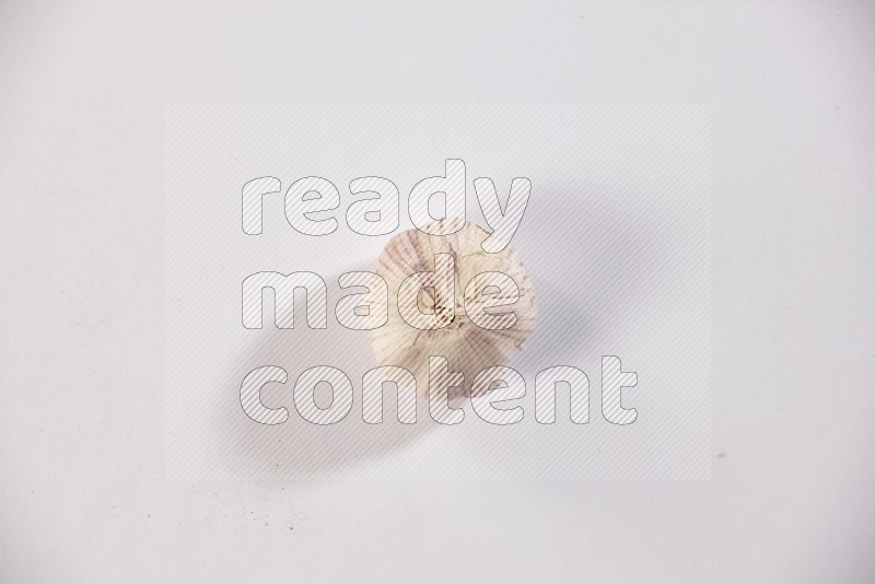 A whole garlic bulb on a white flooring in different angles