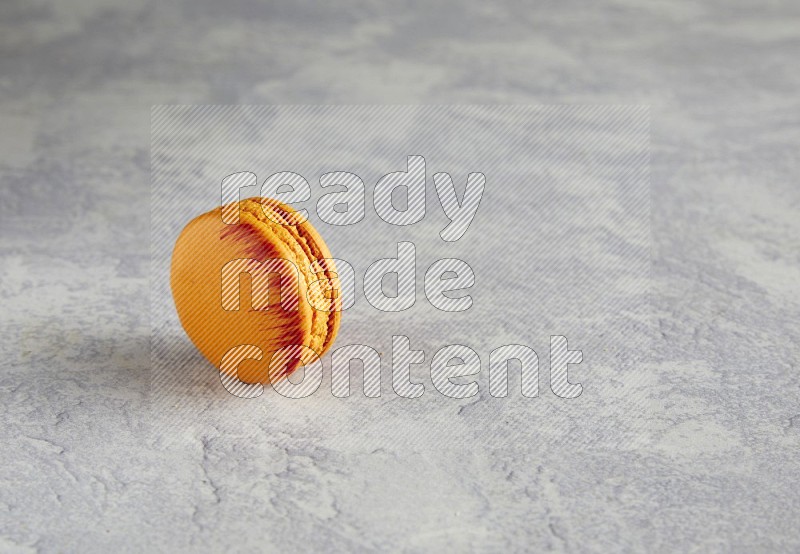 45º Shot of Orange Exotic macaron on white  marble background