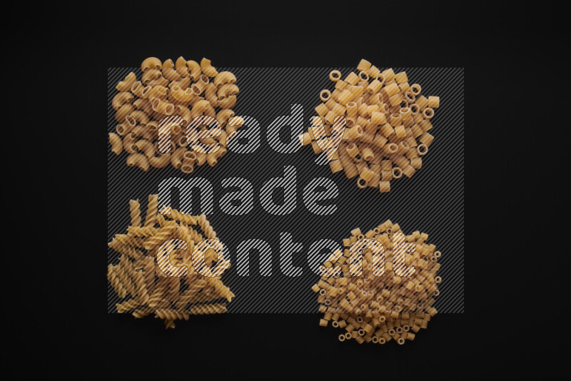 Different pasta types in bunches on black background