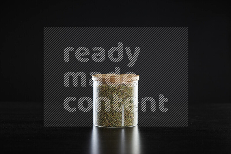 Freekeh in a glass jar on black background