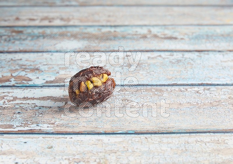 pistachio stuffed madjoul date on a light blue wooden background
