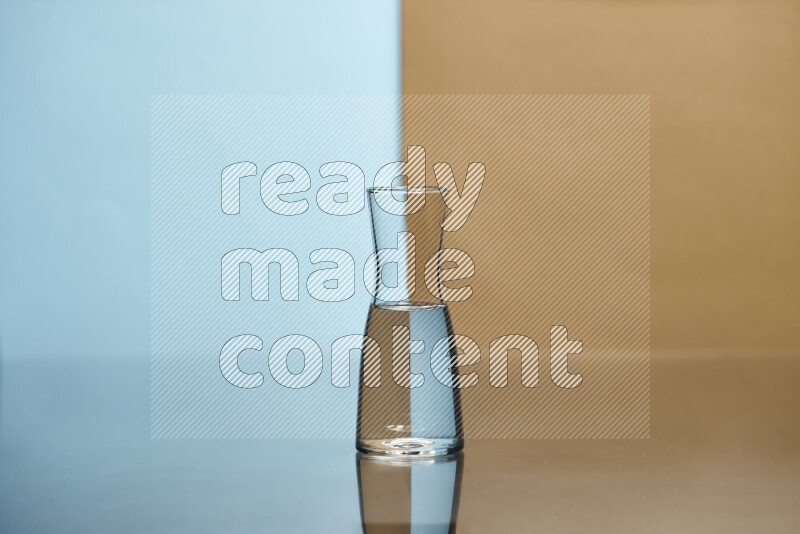 The image features a clear glassware filled with water, set against light blue and beige background