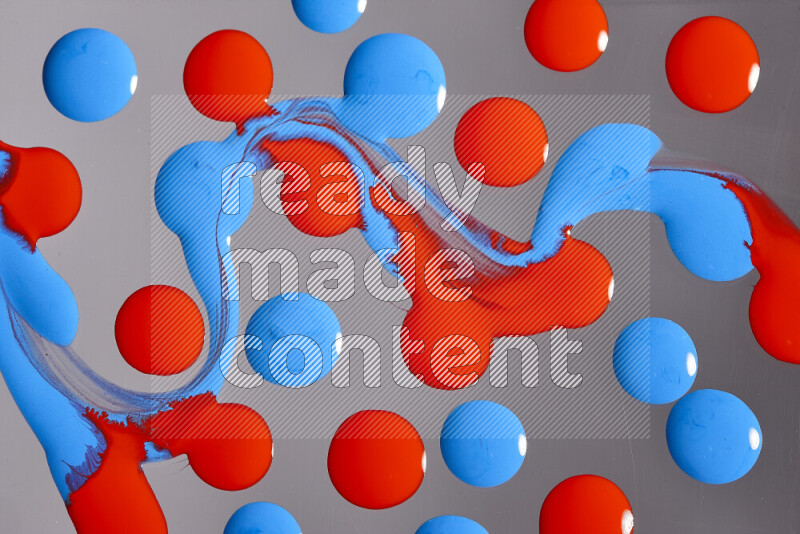 Close-ups of abstract red and blue paint droplets on the surface