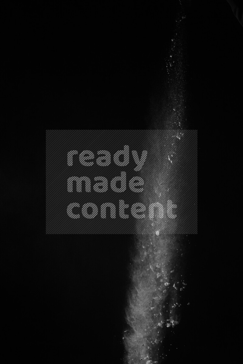 A side view of white powder explosion on black background
