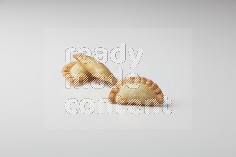 Three fried sambosas on a white background