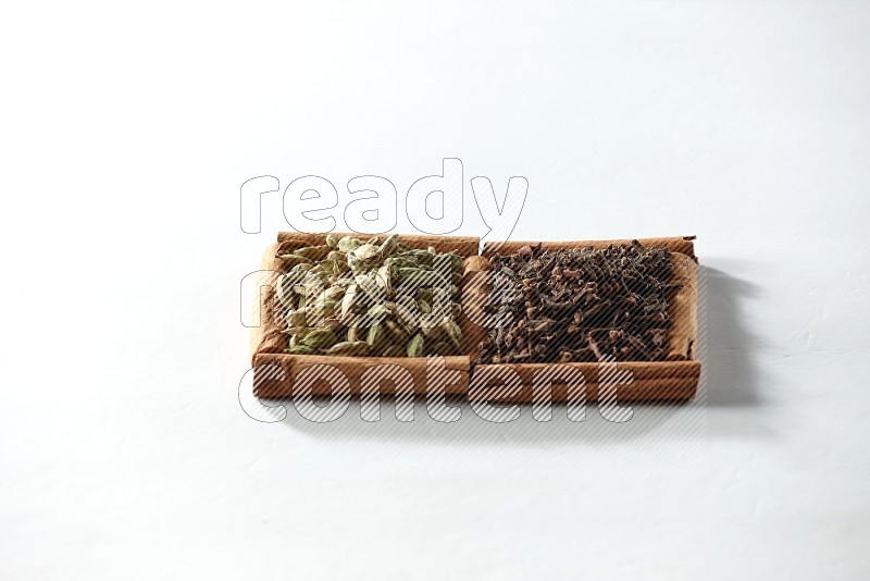 2 squares of cinnamon sticks full of cloves and cardamom on white flooring