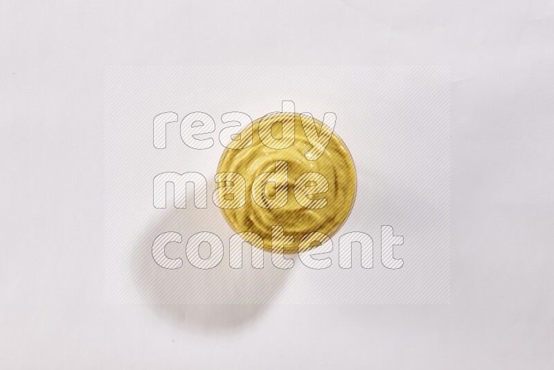 وعاء زجاجي ممتلئ بمعجون الخردل علي خلفية بيضاء