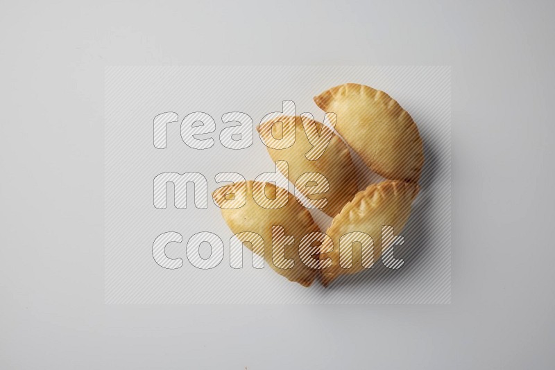Four fried sambosa from a top angle on a white background