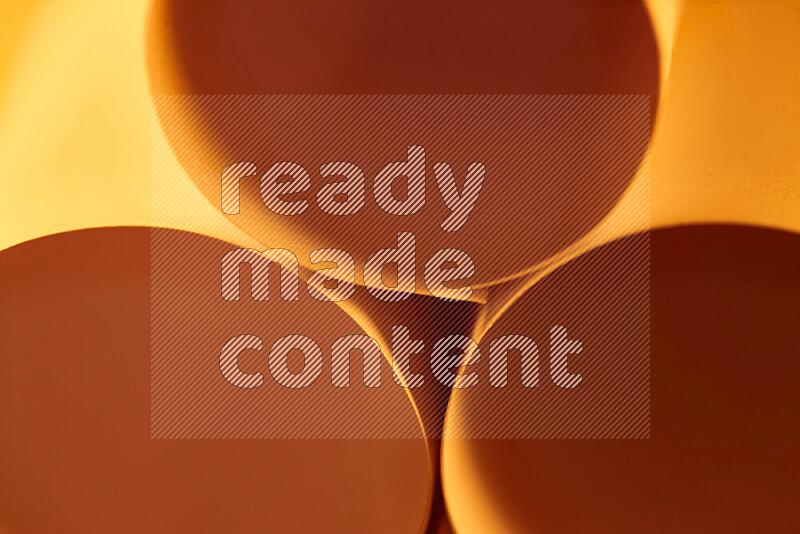 The image shows an abstract paper art with circular shapes in varying shades of orange