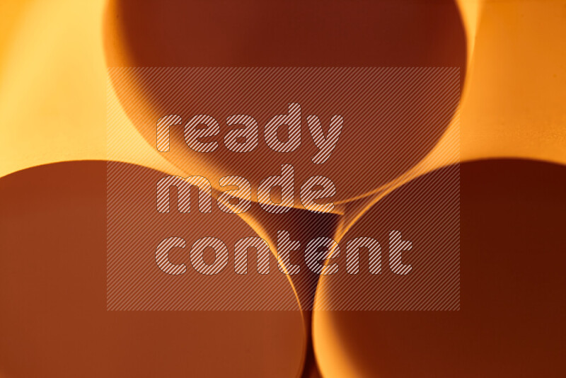 The image shows an abstract paper art with circular shapes in varying shades of orange
