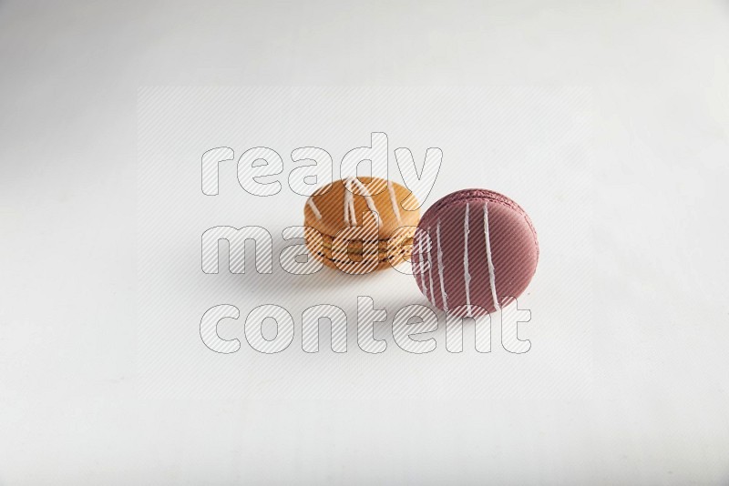 45º Shot of of two assorted Brown Irish Cream, and Red Poppy Flower macarons on white background