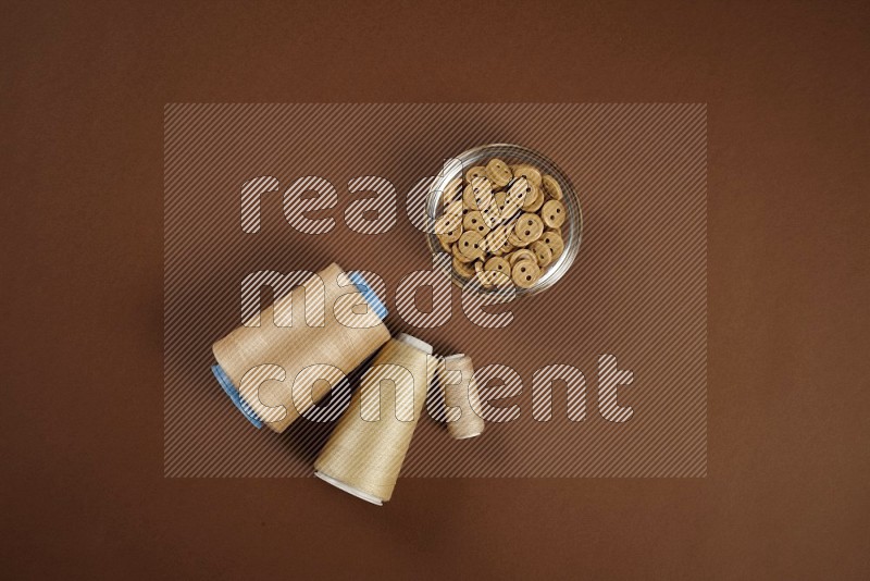 Brown sewing supplies on brown background