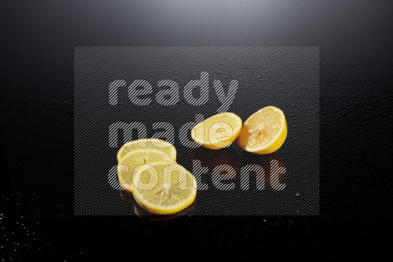 Lemon slices with water drops, and droplets on black background