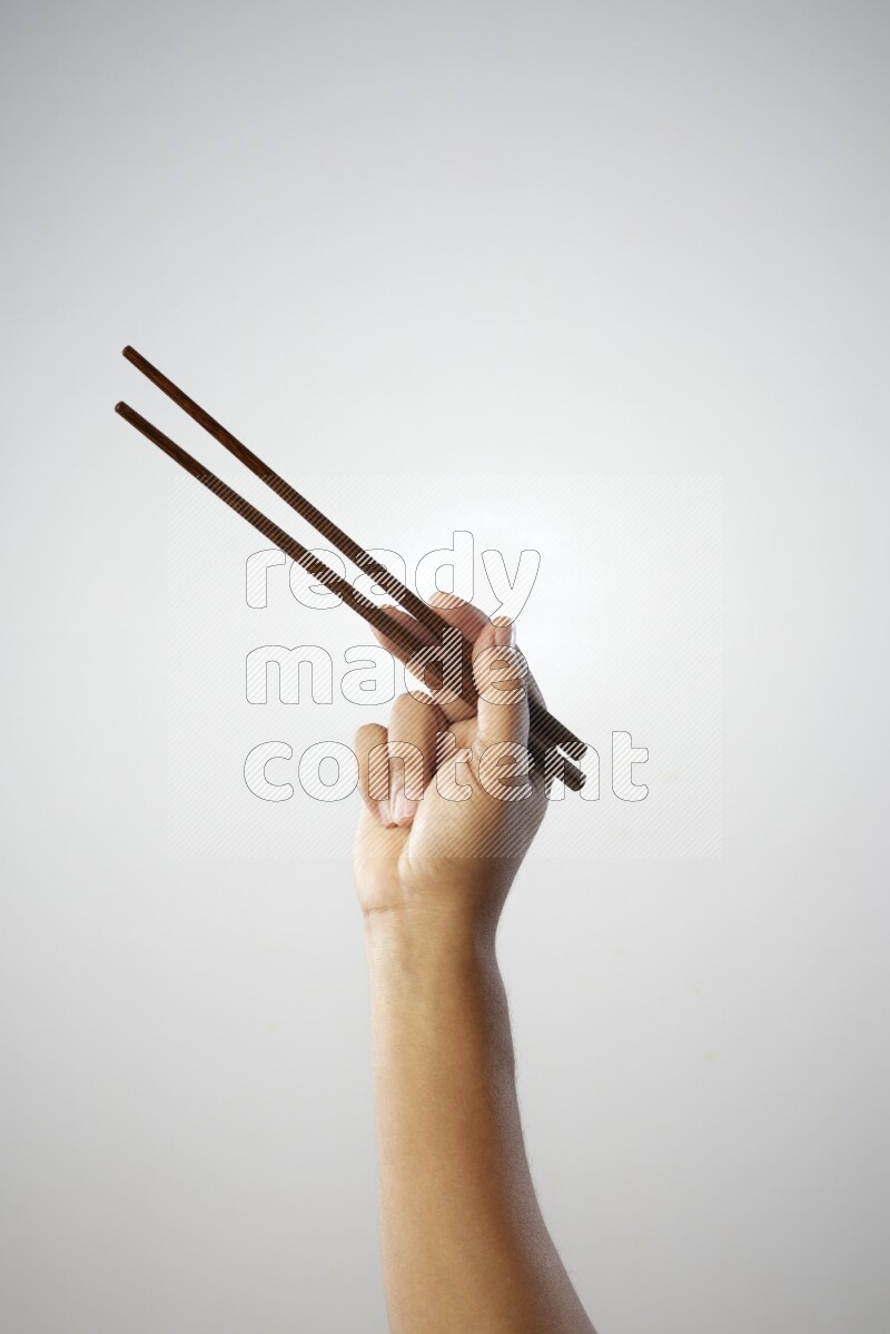 Male Hand Holding Chop Stick on white background