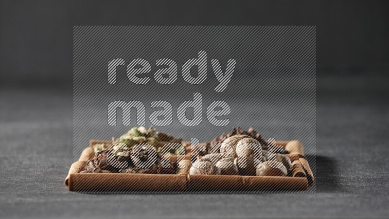 4 squares of cinnamon sticks full of cardamom, star anise, nutmegs and cloves on black flooring