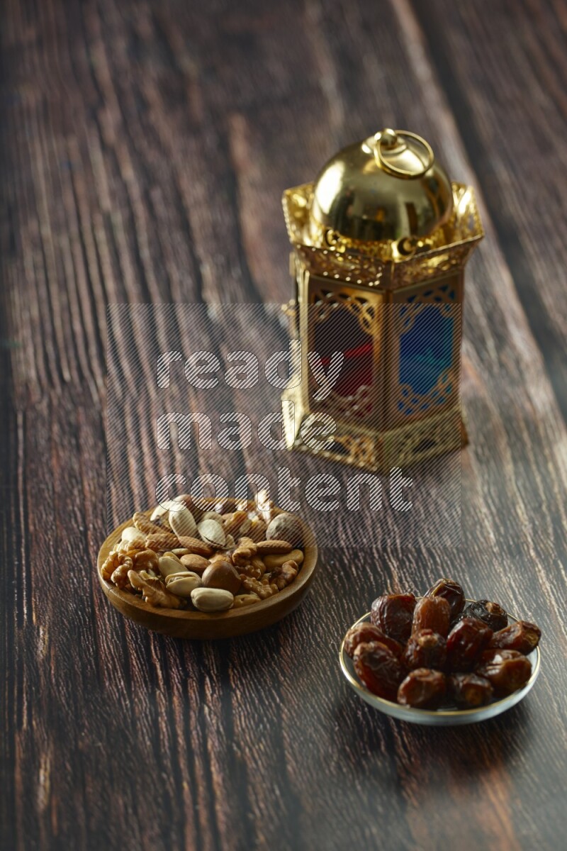 A golden lantern with different drinks, dates, nuts, prayer beads and quran on brown wooden background