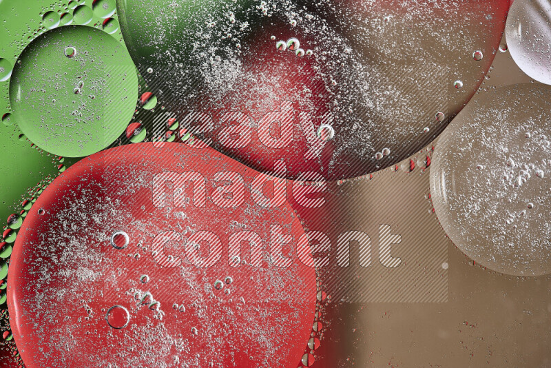 لقطات مقربة لفقاعات من الزيت على سطح الماء باللون البني والأخضر والأحمر