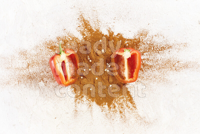 A bunch of ground paprika powder with two halfs of red bell pepper on white background