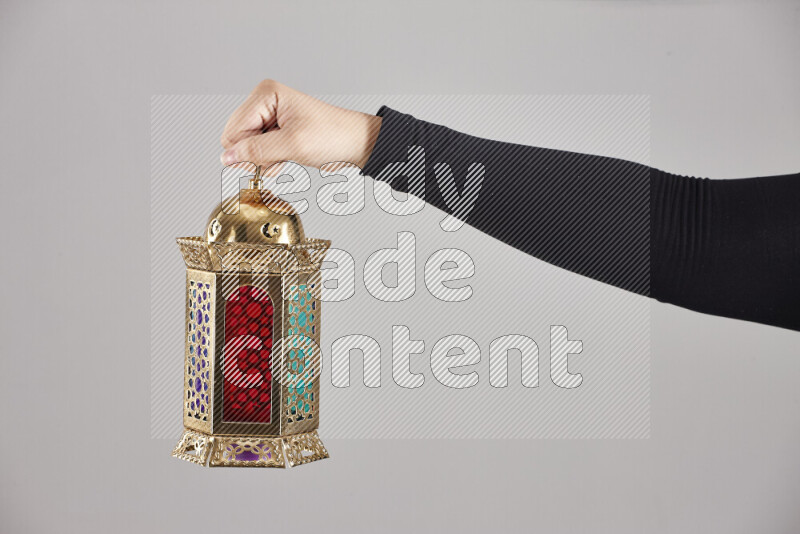 A woman in black abaya holding different ramadan lanterns in different positions