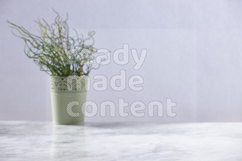 Artificial plant in green decorative pot on grey marble background