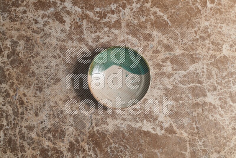 A decorative pottery plate on beige marble background