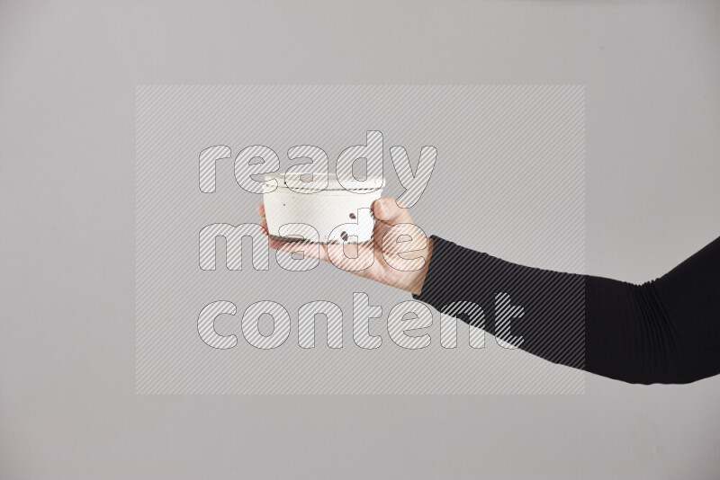 A woman in black abaya holding different pottery essentials in different positions