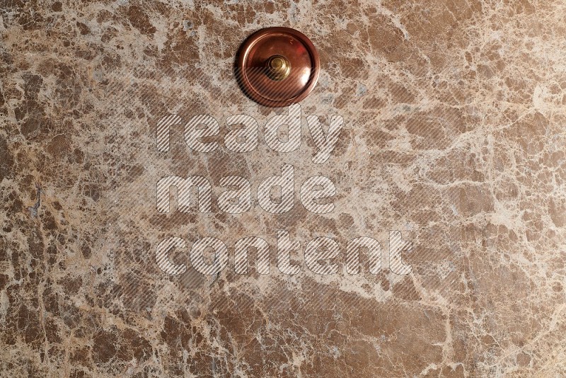 Top View Shot Of A Small Copper Pot On beige Marble Flooring