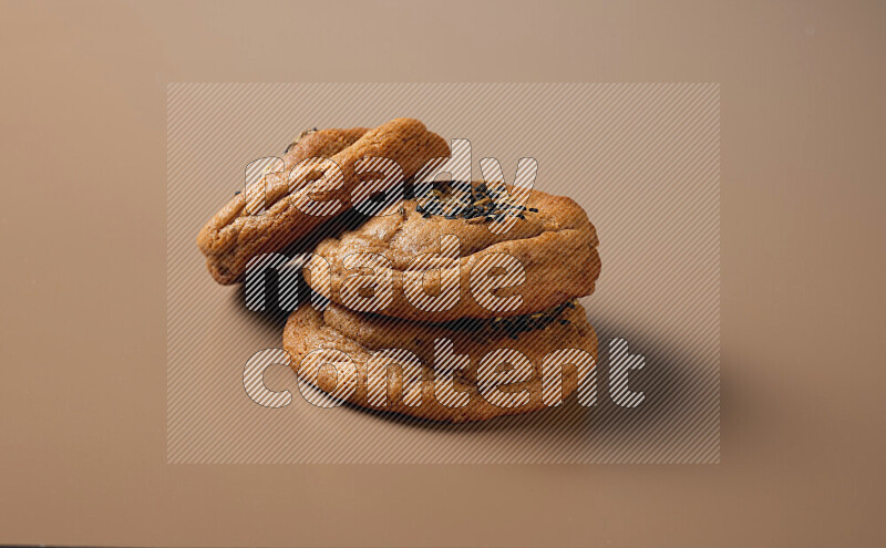Hasawi cookies field with date and decorated by black seed and Anise grain on a brown background