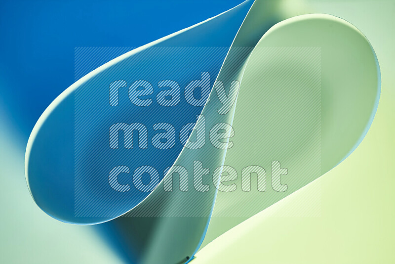 An abstract art of paper folded into smooth curves in green and blue gradients