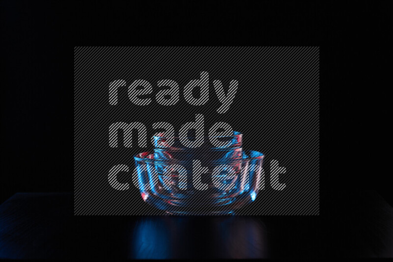 Glassware with rim light in red and blue against black background