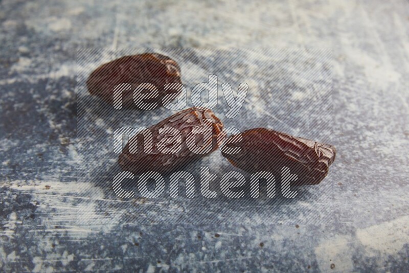 three madjoul dates on a rustic blue backround
