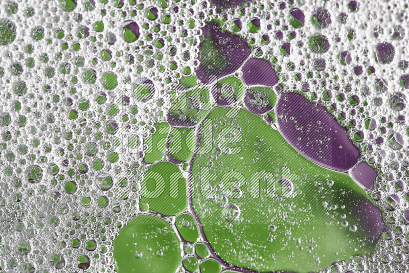 Close-ups of abstract soap bubbles and water droplets on green and purple background