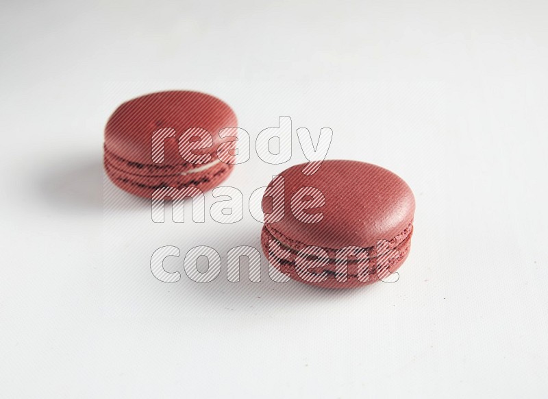 45º Shot of two Red Velvet macarons on white background