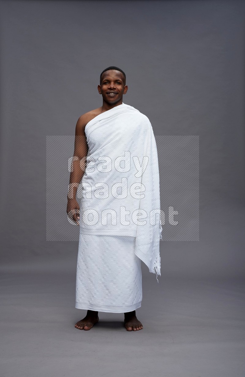 A man wearing Ehram Standing Interacting with the camera on gray background