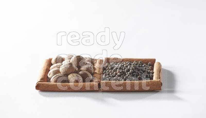 2 squares of cinnamon sticks full of black pepper and nutmegs on white flooring