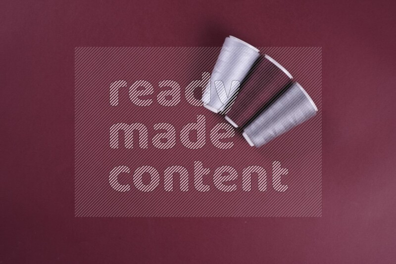 مجموعة من أدوات الخياطة والتفصيل رمادية اللون على خلفية حمراء