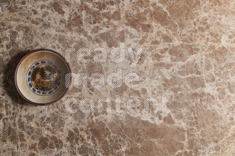 A decorative pottery plate on beige marble background