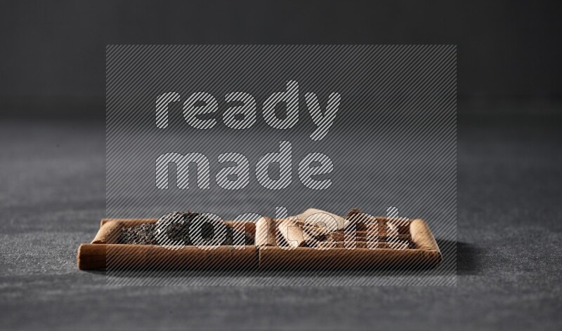 مربعان من أعواد القرفة ممتلئان بالشاي والقرفة علي خلفية سوداء