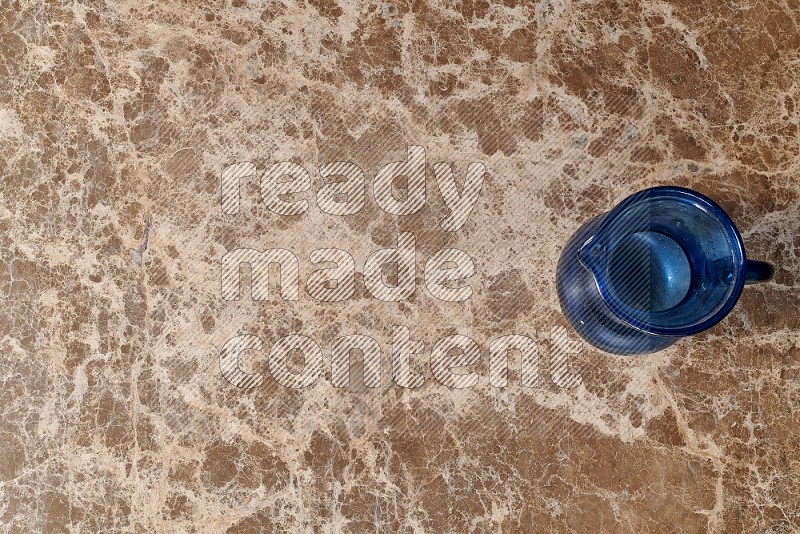 Top View Shot Of An Empty Glass Jug On beige Marble Flooring