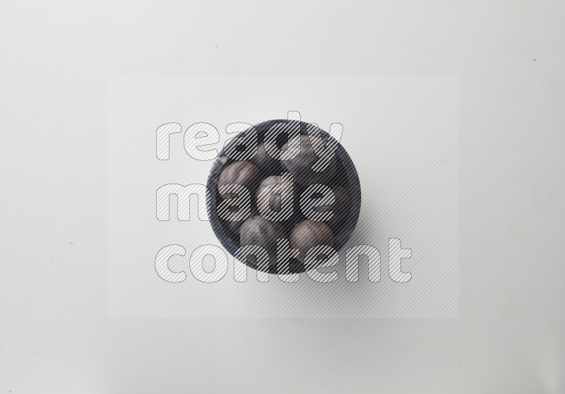 Top-view shot of dried lime (loomi) in a container on white background