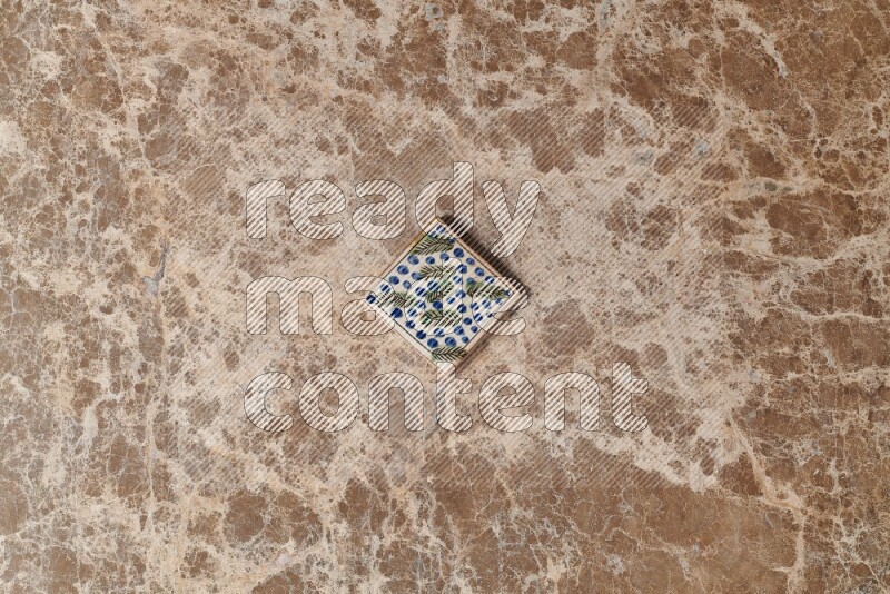 A decorative coaster on beige marble background