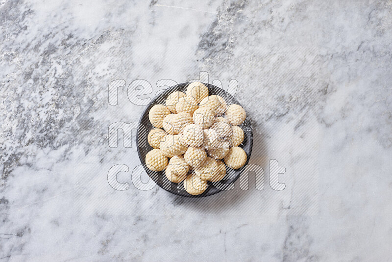 Kahk in black pottery plate on grey marble background